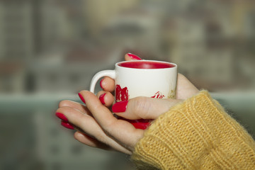 Cup of coffee or tea in womans's hands with good manicure