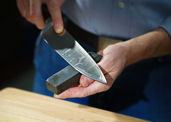 Man sharpens kitchen knife