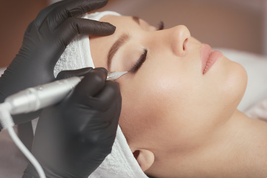 Close up cosmetologist making eyeliner permanent makeup 