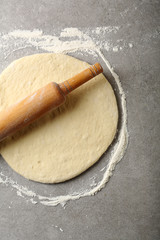 Raw dough and  wooden rolling pin