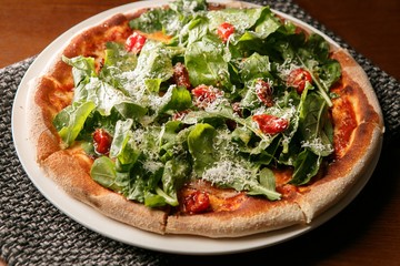 arugula  pizza on table