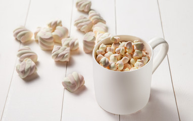 A cup of cocoa with marshmallows on the table.