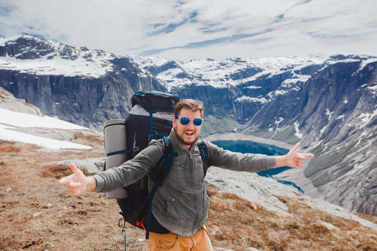 Hiking man portrait with backpack walking in nature. man smiling happy with mountain in background during summer trip in Norway,USA.Canada,Bearded man living fun active lifestyle outdoors.adventure