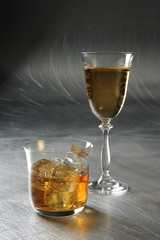 white wine and whiskey on the metal / silver / light background 