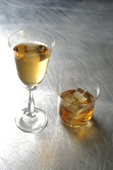 white wine and whiskey on the metal / silver / light background 