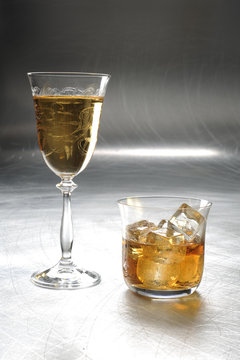 white wine and whiskey on the metal / silver / light background 
