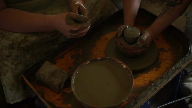 woman's hands makes a pot on pottery wheel
