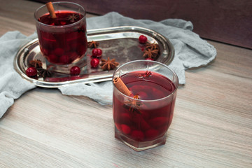 mulled wine with cherries, cinnamon and star anise in a glass on vintage silver tray