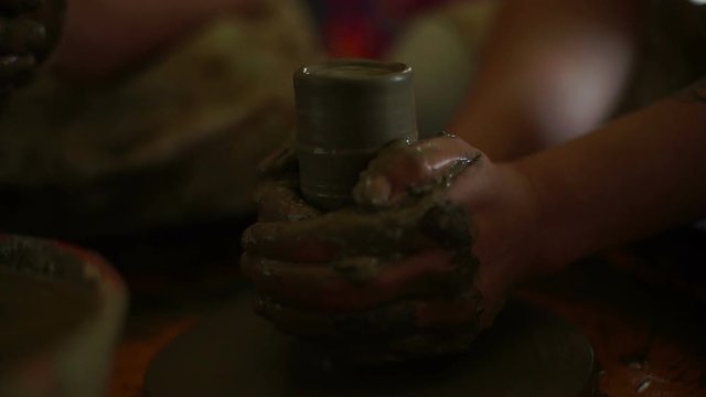 woman's hands makes a pot on pottery wheel