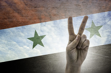 Victory symbol - two fingers against background of Syria flag
