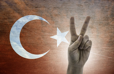 Victory symbol - two fingers against background of Turkey flag