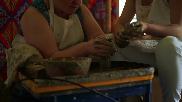 woman's hands makes a pot on pottery wheel