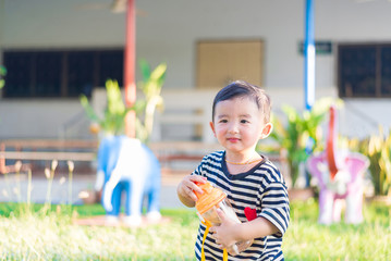 Asian baby boy drink with water bottle at outdoor playground,