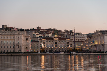 Fototapeta na wymiar Ultimi raggi di sole sul mare e sui palazzi di Trieste