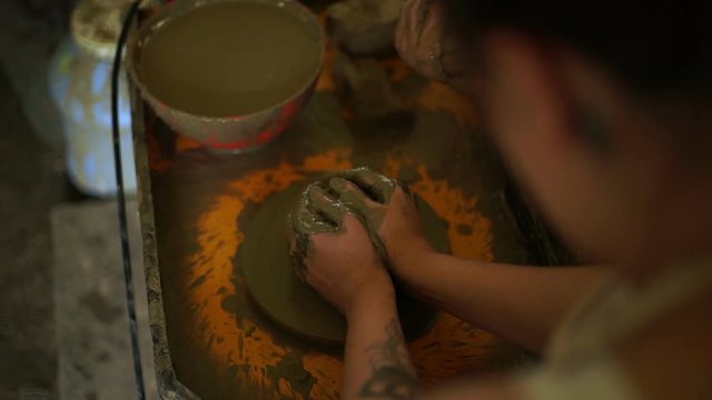 woman's hands makes a pot on pottery wheel