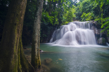 Fototapeta na wymiar Erawan Waterfall, beautiful waterfall with sunlight rays in deep forest, Erawan National Park in Kanchanaburi, Thailand