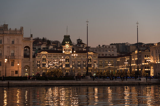 Ultimi raggi di sole sul mare e sui palazzi di Trieste