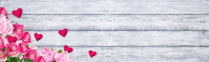 Roses and hydrangeas with hearts on shabby wooden background