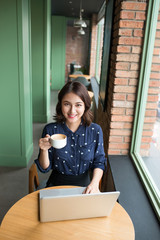 Fototapeta na wymiar Beautiful cute asian young businesswoman in the cafe, using lapt