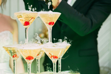 Champagne glasses. Wedding slide champagne for bride and groom. Colorful wedding glasses with champagne. Catering service. Catering bar for celebration. Beauty of bridal interior for wedding 
