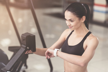 Fototapeta na wymiar Active woman using smart watch in a gym