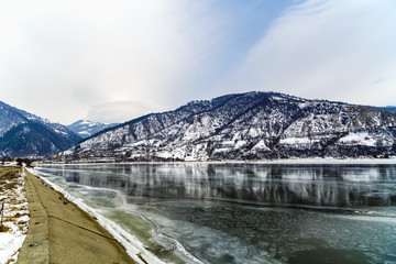 Winter landscape with mountains reflected in the river