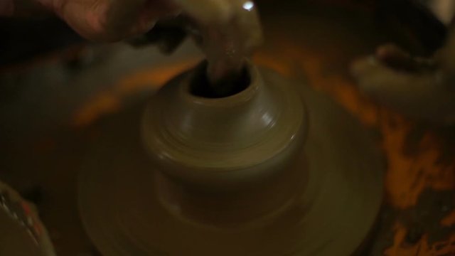 woman's hands makes a pot on pottery wheel