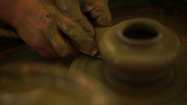 woman's hands makes a pot on pottery wheel
