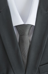 black men's suit with white shirt and grey tie close up