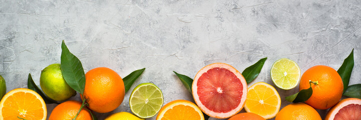 Citrus fruit on grey concrete table. Food background. Healthy eating. Long banner format good for...
