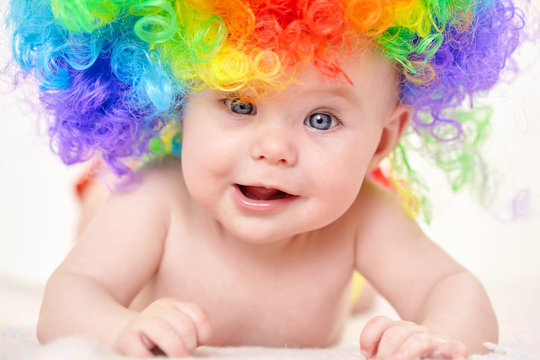 smiling baby girl with colorful wig