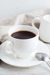 Black coffee in a white cup on a wooden background