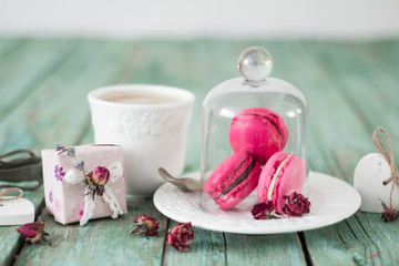 French macaroons cookies gift box and cappuccino cup on a wooden background. Mothers day or Valentines day greeting card