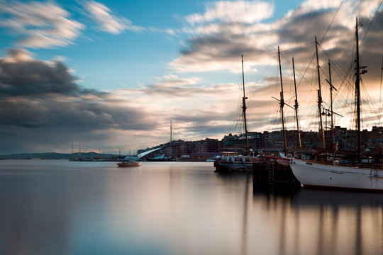 Oslo harbour at sunset. From Rådhusbrygga til Tjuvholmen. Long exposure
