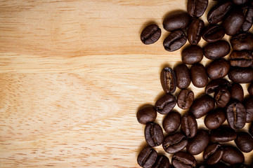 Organic coffee beans on a wooden plate close up background.