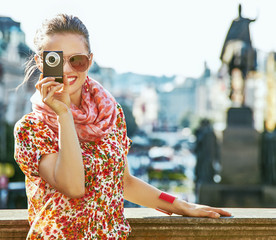 tourist woman with digital camera taking photo in Prague