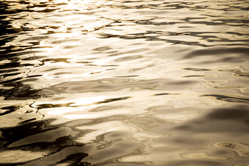 Water surface in lake in evening sun light close up background.