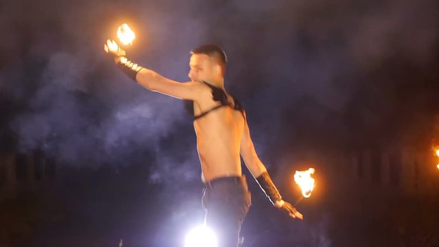 The guy doing a somersault. in the hands of fire. Close-up. Slow motion. flip