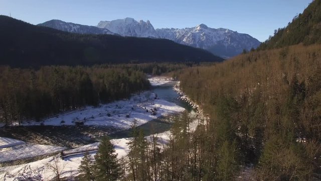 Nature Drone Shot of River in Mountain Forest with Fresh Powder Snow and Blue Sky