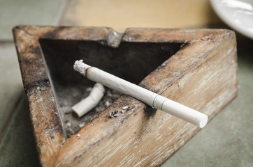 Black wood ashtray with cigarette stubs in closeup