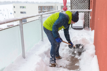 Fototapeta premium Man shoveling the show on the terrace after heavy snowfall