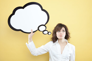 pretty young brunette caucasian woman thinking ideas with comic baloon  on yellow background