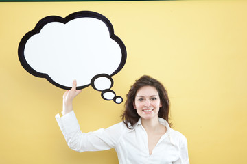 pretty young brunette caucasian woman thinking ideas with comic baloon  on yellow background