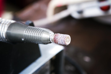 Electric nail file. Manicure in beauty shop.