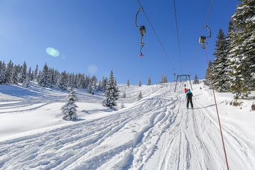 Fototapeta na wymiar Skiers on ski lift, on a lovely sunny day in the carpathian moun