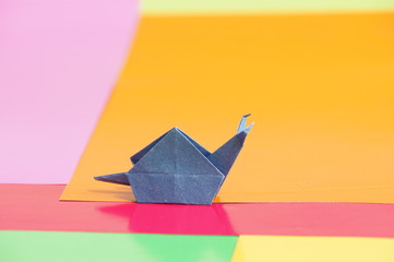 
Paper origami snail isolated on a colorful background