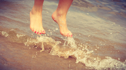 Female feet jump on beach.