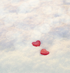 Two red heart on snow. Romantic background by St. Valentine's Day