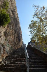 Fototapeta na wymiar long ladder towards sky near stone wall