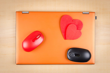 Card for Valentine's Day with two red hearts and two mice on portable PC